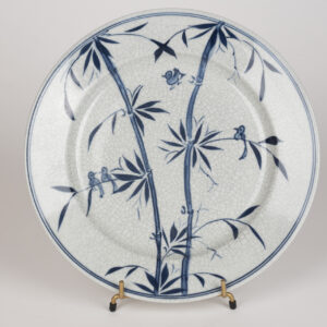 Assiette en porcelaine chinoise bleu et blanc à décor de bambous et oiseaux.