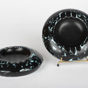 Deux cendriers ronds en céramique noire mouchetée de bleu, dans le goût d'Accolay.