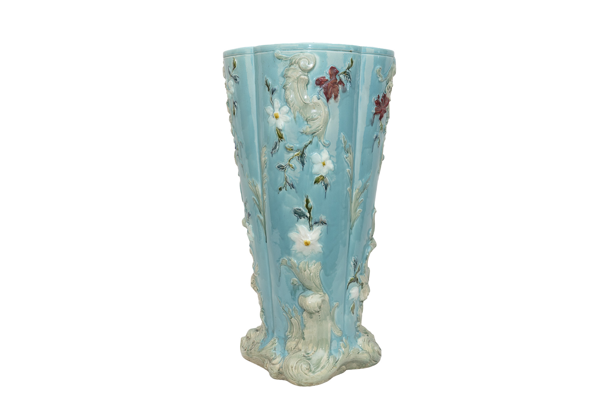 Grand porte-parapluie en barbotine bleu turquoise, orné de fleurs et de feuillages en relief, vu de trois quarts.