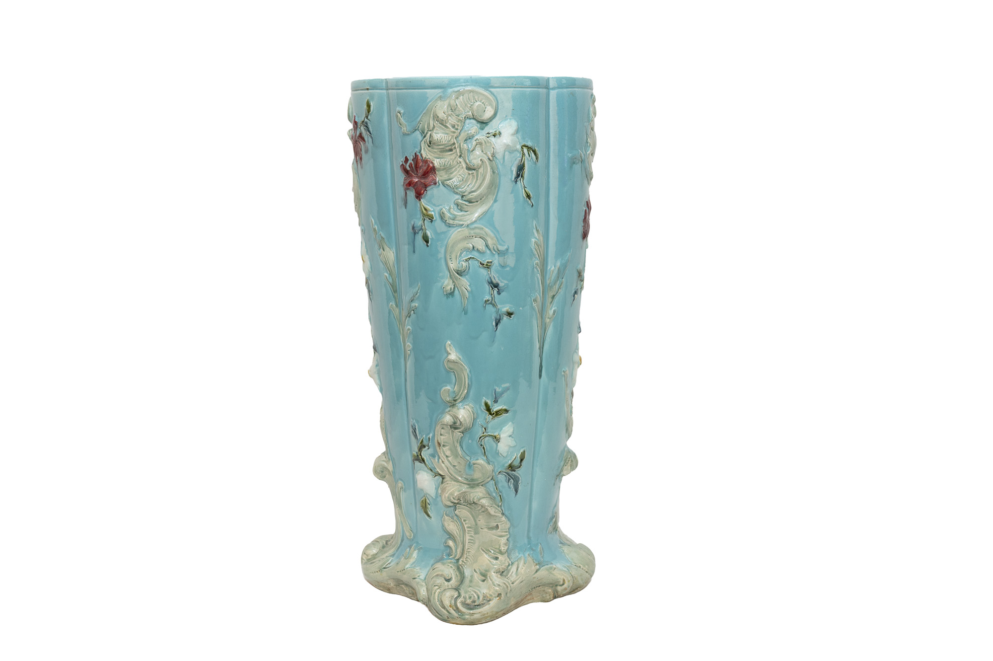Porte-parapluie bleu turquoise en barbotine, avec grandes volutes claires et fleurs en relief.