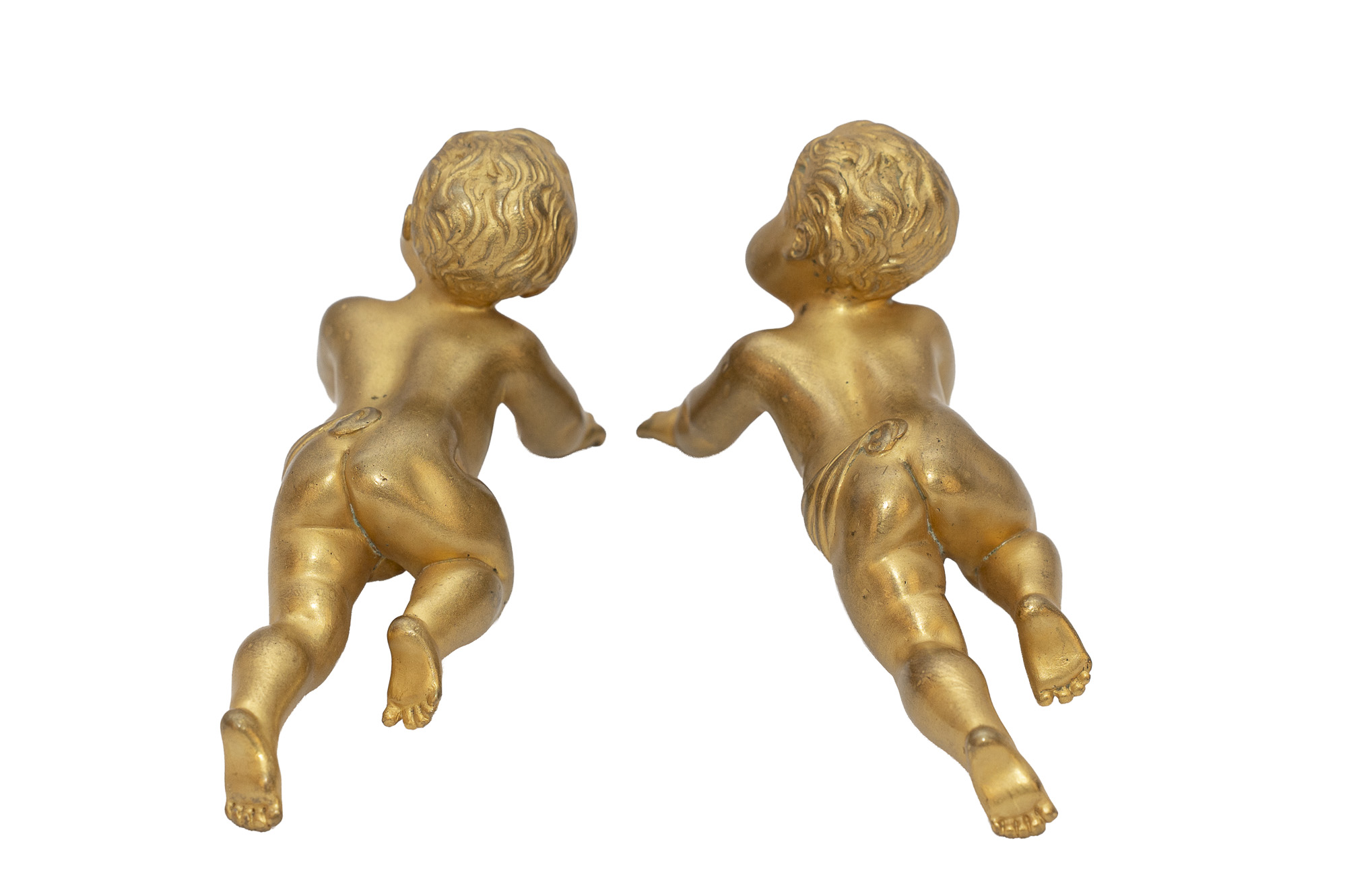 Les deux figures en bronze doré retournées, montrant le dessous des corps, les paumes des mains et les drapés.