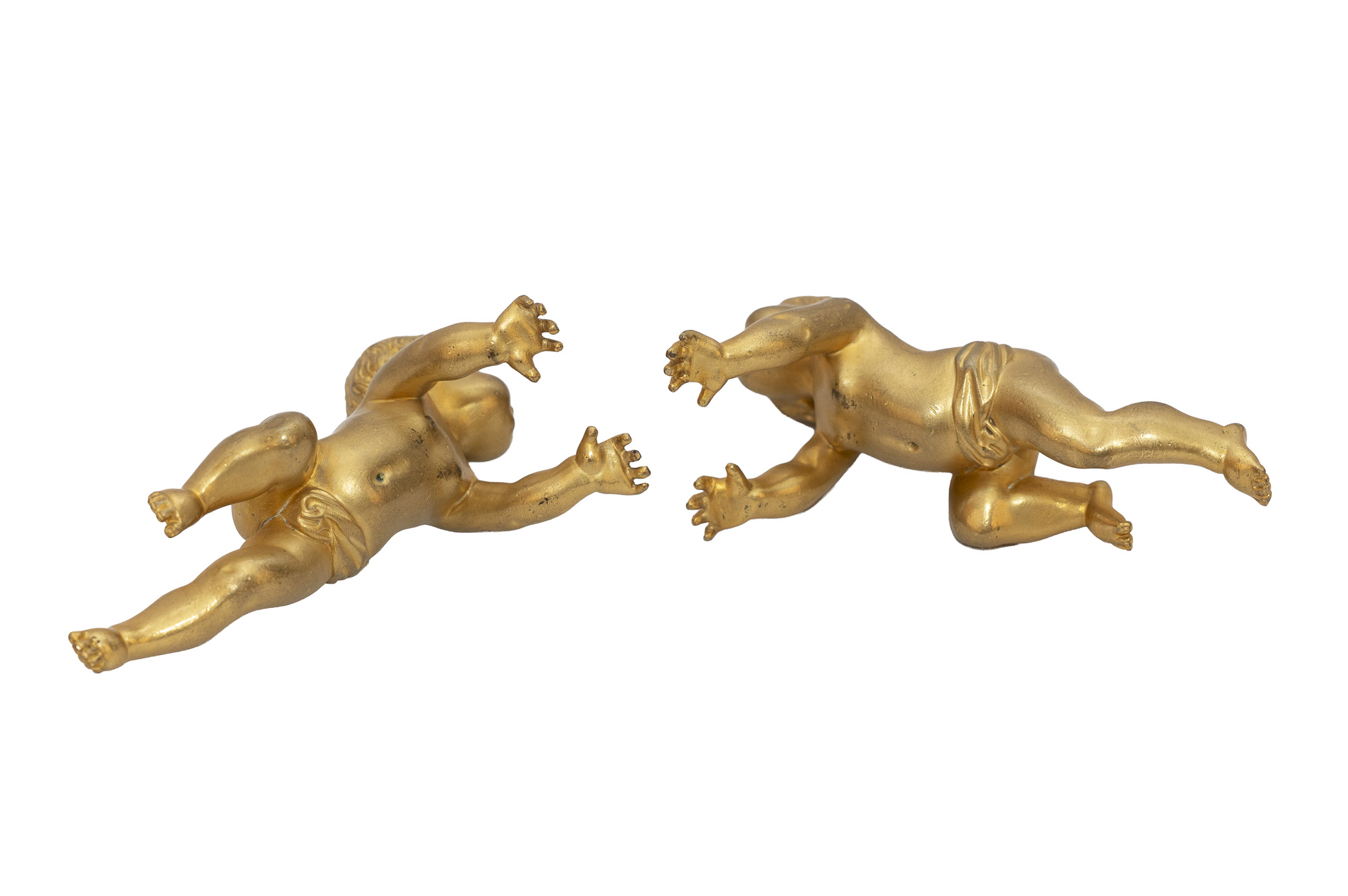 Vue rapprochée des deux enfants en bronze doré, montrant leurs visages, leurs cheveux bouclés et leurs mains.